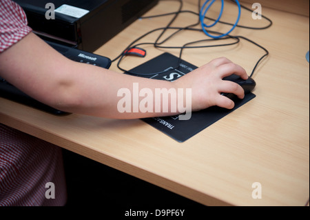 Schulkind mit einer Maus in der IKT-Suite einer Grundschule im Vereinigten Königreich Stockfoto