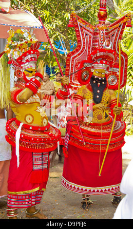 THEYYAM GÖTTER MIT PFEIL UND BOGEN, DIE IN EINER RELIGIÖSEN ZEREMONIE KANNUR KERALA SÜD-INDIEN Stockfoto