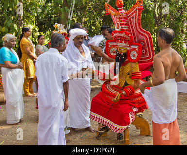 THEYYAM GÖTTER HANDELN IN EINER HINDUISTISCHEN RELIGIÖSEN ZEREMONIE MIT ANHÄNGER IN KERALA SÜD-INDIEN Stockfoto