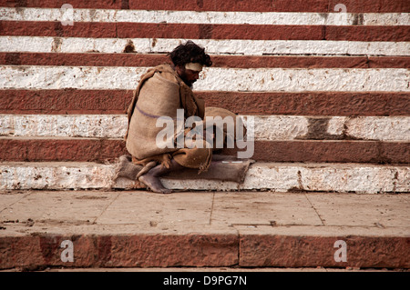 Mann sitzt auf den Ghats. Varanasi, Benares, Uttar Pradesh, Indien Stockfoto