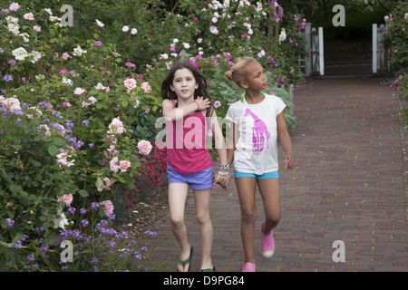 Junge Freunde genießen die Cranford Rosengarten in voller Blüte im Brooklyn Botanic Garden, Brooklyn, NY. Stockfoto