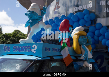 Drei Figuren der Schlümpfe auf eine Werbe Auto. Stockfoto