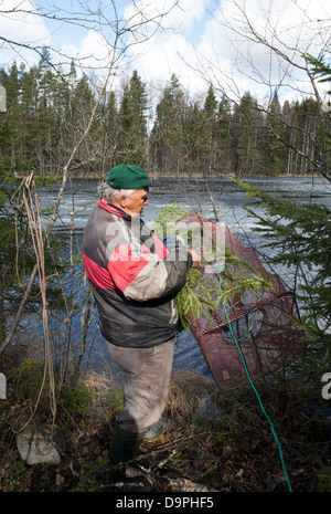Älterer Mann hält eine Topf Falle (Rysä) für Fisch, Finnland Stockfoto