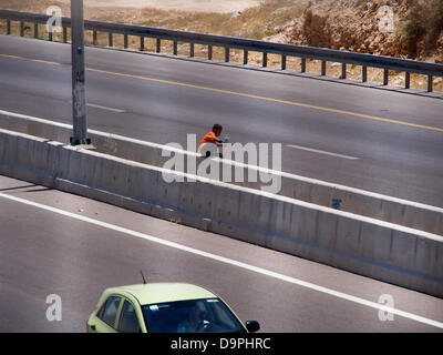 Israel. 24. Juni 2013. Ein jungen Beduinen durchquert gefährlich die vier Fahrspuren Straße 40, die unerkannt Beduinen Dorf von Al Sir in zwei Teile unterteilt. Die Negev-Beduinen Siedlung Behörde plant zu verlagern und das Dorf auf der einen Seite der Straße zu vereinen.  Der Prawer-Begin-Satz soll die Ansiedlung von Beduinen in der Negev-Wüste zu regulieren und wird voraussichtlich in der Knesset heute Abend im ersten von insgesamt drei Lesungen trotz des Widerstands der Beduinen zu übergeben. Bildnachweis: Nir Alon/Alamy Live-Nachrichten Stockfoto