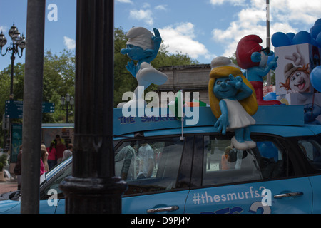 Drei Figuren der Schlümpfe auf eine Werbe Auto. Stockfoto