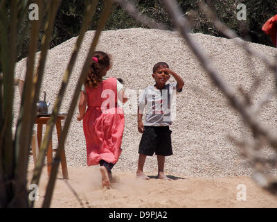 Israel. 24. Juni 2013. Jungen Beduinen-Kinder flirt"" mit der Kamera wie sie barfuß laufen und in der unbekannte Beduinen Dorf Al Sir spielen. Das Dorf leidet die Vernachlässigung der Jahrzehnte. Schulen befinden sich in einer Entfernung von 7 Km.   Der Prawer-Begin-Satz soll die Ansiedlung von Beduinen in der Negev-Wüste zu regulieren und wird voraussichtlich in der Knesset heute Abend im ersten von insgesamt drei Lesungen trotz des Widerstands der Beduinen zu übergeben. Bildnachweis: Nir Alon/Alamy Live-Nachrichten Stockfoto