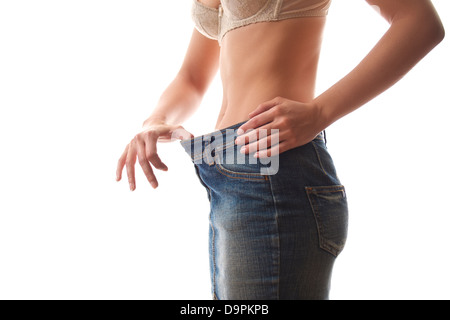 junge Frau Diäten und Gewichtsverlust trägt Jeans Kleid auf weißem Hintergrund zu betrachten Stockfoto