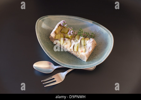 Hausgemachte Rhabarber-Kuchen mit Blumen auf einem grauen Hintergrund. Stockfoto