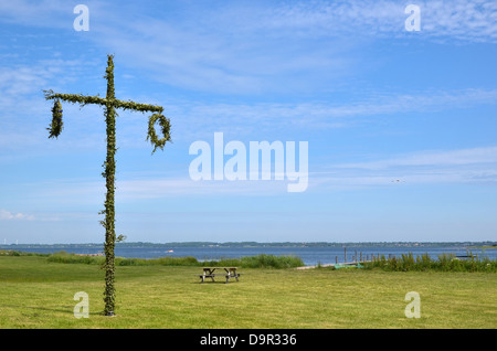 A Maibaum an Küste in Schweden. Symbol zum Mittsommer Feiern. Stockfoto