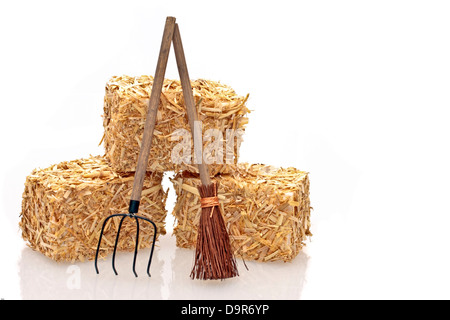 Heuballen mit Werkzeugen auf weißem Hintergrund Stockfoto