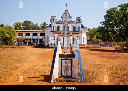 Grabstein auf dem Friedhof mit der Kirche im Hintergrund, Goa, Indien Stockfoto