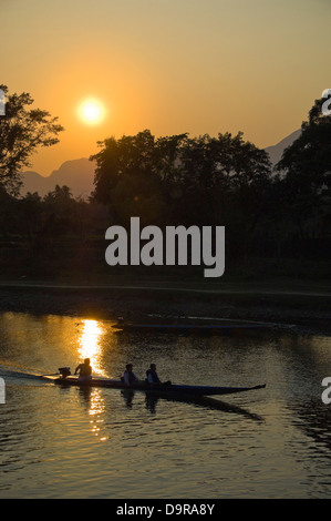 Vertikale Ansicht eines Motorbootes auf dem Nam Song River in Vang Vieng bei Sunet unterwegs. Stockfoto