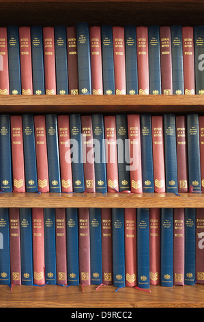 Reihen von Lied und Gebet Gottesdienst Bücher abwechselnd ordentlich Farbreihenfolge auf Eiche Regal Bücherregal Stockfoto