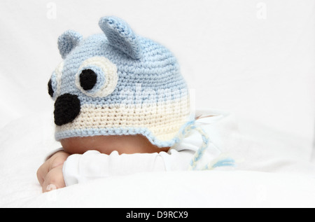 Baby mit einem blauen Mütze Baby auf Magen Stockfoto