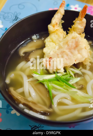 Top Aussicht Udon-Nudeln mit Garnelen-Tempura in schwarz Schüssel, japanisches Essen Stockfoto