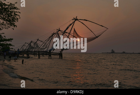 Chinesische Fischernetze bei Sonnenuntergang in Fort Cochin (Kochi) in Kerala, Indien Stockfoto