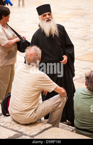 Israel Jerusalem Altstadt Kirche des Heiligen Grabes Grab Innenhof Griechisch-orthodoxen Priester langen weißen Bart minister Chats für Besucher Stockfoto