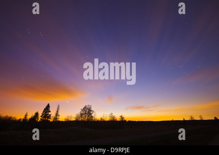 Hohes Venn, Belgien nachts mit unscharfen beleuchtete Wolken und Sternen. Stockfoto