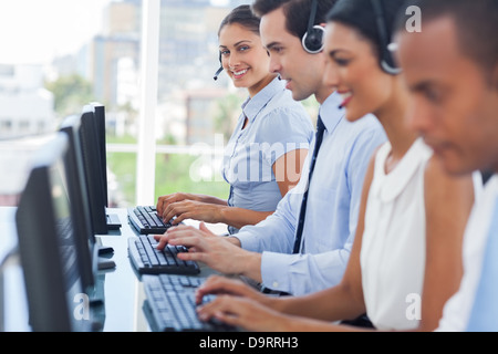 Lächelnd Call-Center-Mitarbeiter, die Arbeit am Computer Stockfoto