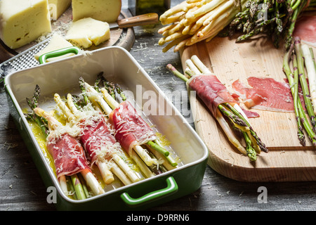 Zubereitung von Spargel, eingehüllt in Parma-Schinken mit Käse Stockfoto