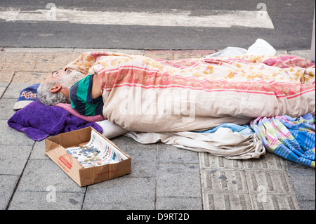 Israel Tel Aviv Jaffa Jaffa bärtigen alten alten Bettler betteln, Hobo tramp schlafen Obdachlose Pflaster Zebrastreifen der Hauptstraße decke Blatt Federbett Stockfoto