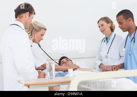 Ärzteteam unter den Herzschlag eines Patienten Stockfoto