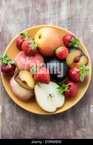 Frische Sommerfrüchte in Platte über hölzerne Hintergrund Stockfoto