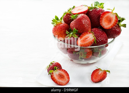 Strawberries in glass bowl on light background, selective focus, copy space Stockfoto