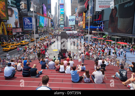 PUBLIKUM SITZEN AUF ROTEN SCHRITTE TKTS CENTER TIMES SQUARE UND MIDTOWN MANHATTAN NEW YORK CITY USA Stockfoto