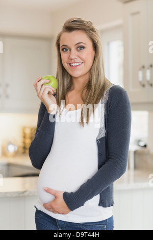 Schwangere Frau hält einen Apfel Stockfoto