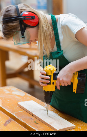 Student in einer Holz-Klasse mit einem Bohrer Stockfoto