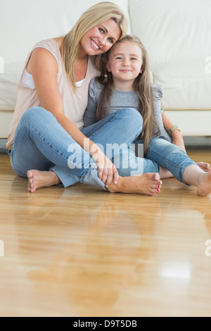 Mutter und Tochter sitzen auf den Boden umarmen Stockfoto