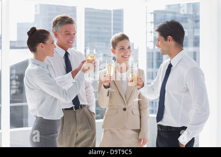 Lächelnd Team von Geschäftsleuten, die ihre Flöten Champagner Klirren Stockfoto