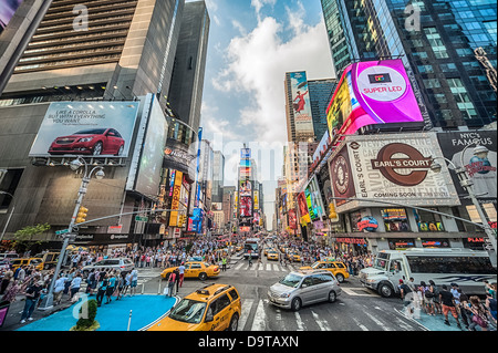 Taxis und eine Sightseeing-Busse voller Touristen gehen durch Times Square New York City. Stockfoto