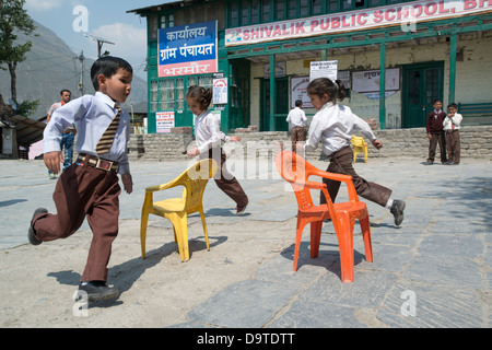 Indische Grundschulkinder spielen Reise nach Jerusalem auf dem Dorfplatz auf Bharmour, Himachal Pradesh, Indien Stockfoto