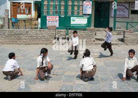 Indische Grundschulkinder spielen Sie eine Partie von Kho Kho auf dem Dorfplatz in Bharmour, Himachal Pradesh, Indien Stockfoto