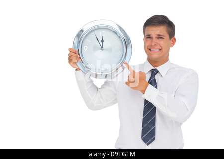 Ängstlich Geschäftsmann hält und zeigt eine Uhr Stockfoto