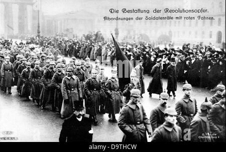 Deutsche Revolution 1918/1919: Menschenmassen nehmen am Trauerzug für die Opfer der Revolutionstage in Berlin am 20. November 1918 Teil. Hier: Delegationen der Betriebsräte tragen vor dem Brandenburger Tor Warnflaggen auf dem Weg zum Friedhof der Märzgefallenen (beleuchtet. "Friedhof der im März im Einsatz getöteten", der sich auf die Opfer der Revolutionen von 1848 in den deutschen Staaten bezieht). Fotoarchiv für Zeitgeschichte Stockfoto