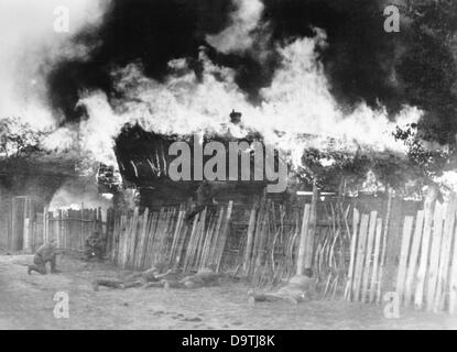 Der NS-Propaganda! auf der Rückseite des Bildes liest: "Military Police kämpft mit bolschewistischen Banden. Während der Nacht haben deutsche Polizeieinheiten in Zusammenarbeit mit Panzern die Bandit Post enger und enger, umkreist, die schließlich in Flammen aufging. Nun ist in der Morgendämmerung, ein Angriff gegen das brennende Dorf ins Leben gerufen. Bild aus der östlichen Front/Russland, 14. Oktober 1943. Der Angriff auf die Sowjetunion durch das Deutsche Reich wurde im Juli 1940 einig und seit Dezember 1940 als "Operation Barbarossa" vorbereitet. Am 22. Juni 1941 begann die Invasion durch die deutsche Wehrmacht. Foto: Berliner Verlag Stockfoto