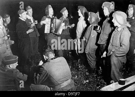 Der NS-Propaganda! auf der Rückseite des Bildes liest: "deutsche Lieder gesungen, unter dem Sternenhimmel im Osten. Mit einer Flak Batterie im mittleren Abschnitt der Ostfront: wieder einmal Bier verteilt und eine fröhliche Nacht gefeiert. Die Kameraden konnten die Härten des Kampfes für mehrere Stunden, vergessen, singen Lieder aus ihrer Heimat. " Bild von der Ostfront, 3. August 1942. Der Angriff auf die Sowjetunion durch das Deutsche Reich wurde im Juli 1940 einig und seit Dezember 1940 als "Operation Barbarossa" vorbereitet. Am 22. Juni 1941 begann die Invasion durch die deutsche Wehrmacht. Stockfoto