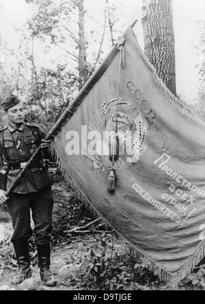 Die Nazi-Propaganda! Auf der Rückseite des Bildes steht: "Kriegsbeute vom See Ladoga. Während heftiger Abwehraktionen im Süden des Ladoga-Sees wurde diese sowjetische Flagge gefangen genommen. Proletarier der Welt, vereinigt euch! Ist das Motto, unter dem seine Träger und diejenigen, die ihnen folgten, in den Tod geführt wurden.“ Ein Bild von der Ostfront/Russland, 13. August 1943. Der Angriff des Deutschen Reiches auf Russland wurde im Juli 1940 vereinbart und seit Dezember 1940 als "Operation Barbarossa" vorbereitet. Am 22. Juni 1941 begann die Invasion der Sowjetunion durch die deutsche Wehrmacht. Fotoarchiv für Zeitgeschichte Stockfoto