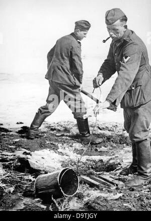 Die Nazi-Propaganda! Auf der Rückseite des Bildes steht: "Vom Alltag unserer Infanteristen in der Donets-Gegend. Aufgrund der anhaltenden Auftauzeit im südlichen Teil müssen die Infanterieposten und Schützengräben ständig von Schneewasser befreit werden - eine mühsame tägliche Detailarbeit der Infanteristen." Bild der Ostfront, veröffentlicht am 22. April 1942. Der Angriff des Deutschen Reiches auf die Sowjetunion, wie im Juli 1940 vereinbart und im Dezember 1940 als "Operation Barbarossa" vorbereitet. Am 22. Juni 1941 begann die Invasion der deutschen Wehrmacht. Fotoarchiv für Zeitgeschichte Stockfoto