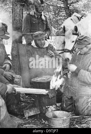 Die Nazi-Propaganda! Auf der Rückseite des Bildes steht: 'Ein Durchbruch im Wald. Der Ofen wird schnell aufgestellt, damit sich Mensch und Tier erwärmen können.“ Bild veröffentlicht am 1. März 1944. Ort unbekannt. Fotoarchiv für Zeitgeschichte Stockfoto