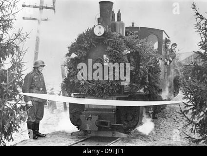 Die Nazi-Propaganda! Auf der Rückseite des Bildes steht: "Die Feldbahn (Schmalspurbahn) an der Ostfront. Der mit Kranz versehene Zug reißt ein weißes Band und öffnet die Zugstrecke." Bild der Ostfront, veröffentlicht am 20. November 1942. Der Angriff des Deutschen Reiches auf die Sowjetunion wurde im Juli 1940 beschlossen und seit Dezember 1940 als "Operation Barbarossa" vorbereitet. Am 22. Juni 1941 begann die Invasion der Sowjetunion durch die deutsche Wehrmacht. Fotoarchiv für Zeitgeschichte Stockfoto