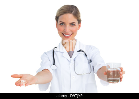 Lächelnde Krankenschwester Drogen und Wasserglas geben Stockfoto
