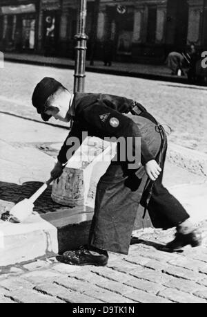 Ein Junge, der die Uniform der Deutschen Jugend trägt, malt im August 1940 in Berlin Bordsteine zum Schutz vor feindlichen Luftangriffen. Fotoarchiv für Zeitgeschichte Stockfoto