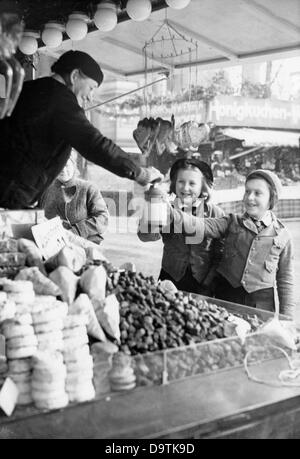 Mädchen der Deutschen Mädchenliga (BDM) sammeln im Dezember 1938 auf einem Weihnachtsmarkt Spenden für die Winterhilfe des deutschen Volkes. Fotoarchiv für Zeitgeschichte Stockfoto