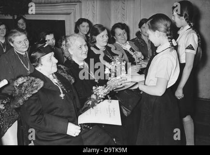 Propagandatext des nationalsozialistischen Berichts auf der Rückseite des Bildes: "Muttertag 1941 in Berlin. Anlässlich des Muttertags 1941 fanden in Berlin individuelle Zeremonien statt, bei denen etwa 3.000 Berliner Mütter mit dem Mutterhonorenkreuz ausgezeichnet wurden. In der Waffenhalle von Schloss Köpenick erfreuen sich die BDM-Mädchen den Müttern nach der Auszeichnung mit frischen Blumen." Bild vom 11. Mai 1941. Fotoarchiv für Zeitgeschichte Stockfoto