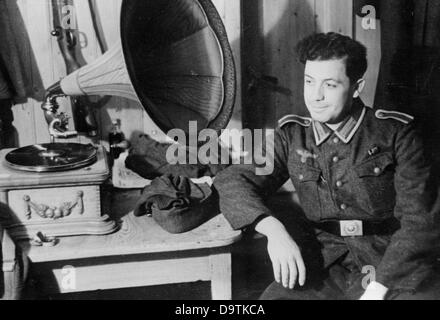 Ein Soldat hört Musik auf einem Tonträger an der Ostfront, 21. Februar 1944. Ort unbekannt. Die Nazi-Propaganda! Auf der Rückseite des Bildes steht: "Von der Jugend, von der Jugend". Der Phonograph, der die Melodien in der alten Mode wiedergibt, ist so alt wie die Melodie; er ist sozusagen aus der Jugend der Musikaufnahmen. Trotzdem haben unsere Landser (Squaddies) Spaß, und daher erfüllt die Maschine ihren Zweck.“ Fotoarchiv für Zeitgeschichte Stockfoto