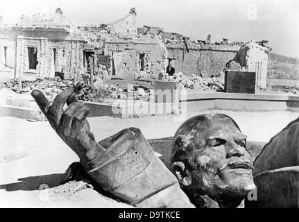 Ein zerstörter Lenin-Denkmal ist vor Ruinen in Sewastopol auf der Halbinsel Krim in der Ukraine, Juli 1942 abgebildet. Der NS-Propaganda! auf der Rückseite des Bildes ist vom 13. Juli 1942: "ein Symbol für eine untergehende Welt. In Sewastopol, wo die südlichen und nördlichen Ufer aufgeteilt sind, stand einst eine unvermeidliche Lenin-Denkmal. Es war aus Metall und meterhohen machte, weil es angeblich die größte Marinebasis der Sowjetunion montiert werden. Nun, der Luftdruck einer Stuka-Bombe führte ihn nach unten. Die schwere Masse klebt Ddep im Beton, nur einer Hand ist genau wie der Han errichtet Stockfoto